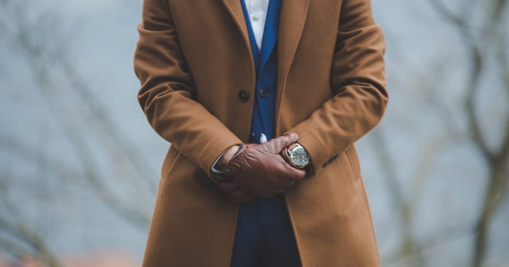 a man wearing a pea coat over a blue suit