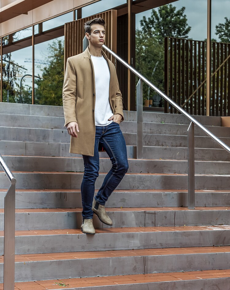 elegant man on chelsea boots walking down stairs