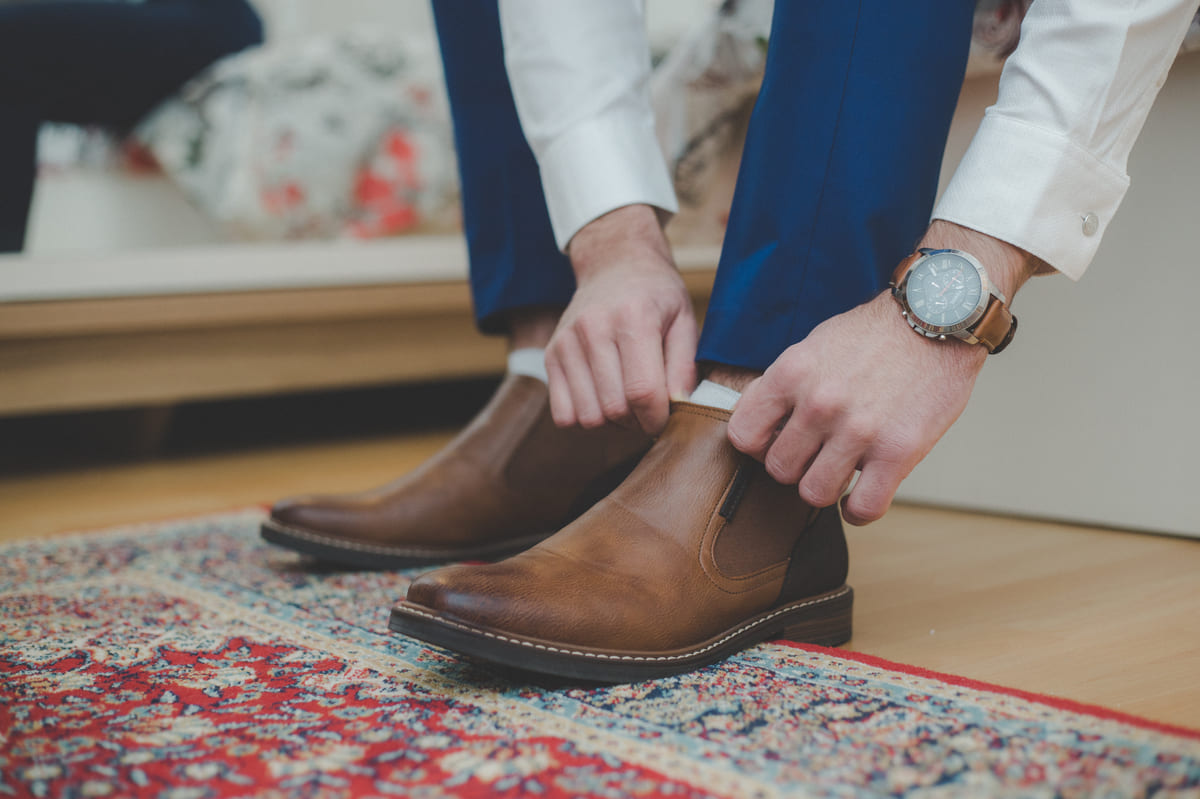 a man putting on chelsea boots